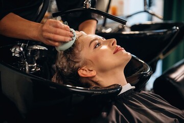 Healthy massage for the head and skin. Woman is in a beauty salon with hair stylist