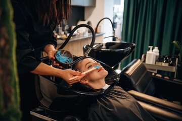 Hair coloring, blue. Woman is in a beauty salon with hair stylist