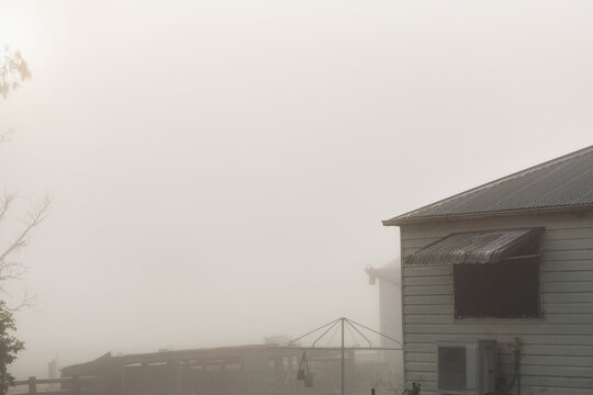 farm buildings on foggy morning shrouded in mist