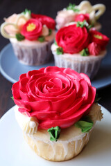 Closeup of a gorgeous red rose frosting cupcake with another cupcakes in the backdrop
