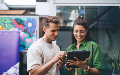 Man and woman sharing tablet and stylus, engaged in collaborative interaction, showing creative...