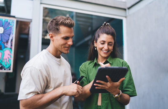 Smiling man and woman analyzing content on tablet, stylus in hand, representing user-centered design process, digital creativity, and casual teamwork in modern mobile workflow.