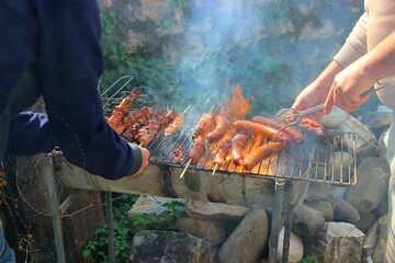 Greek souvlaki and sausages grilling outdoors