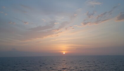 Obraz premium Soft pastel sky at sunrise over calm sea with subtle reflections