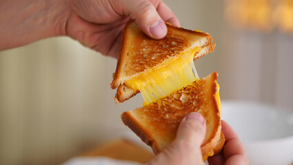 Hands Pulling Apart a Classic Grilled Cheese Sandwich with a Gooey, Stretchy Melted Cheese Pull