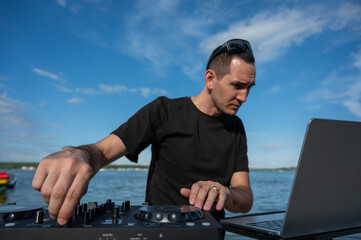 Caucasian man works as a DJ on the beach. 