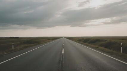 Naklejka premium Straight Road Stretching into the Horizon Under a Cloudy Sky