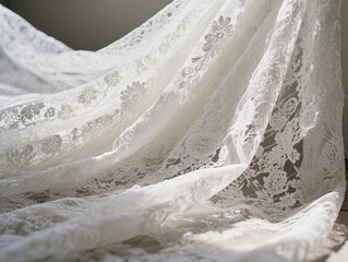 Delicate white lace fabric with a close-up floral pattern. The folds in the lace fabric create elegant texture and depth for wedding and fashion designs.