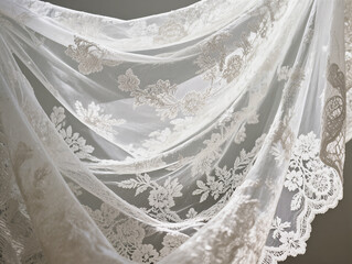 Delicate white lace fabric with a close-up floral pattern. The folds in the lace fabric create elegant texture and depth for wedding and fashion designs.