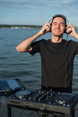 Caucasian man works as a DJ on the beach. 