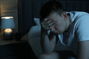 Obraz premium Frustrated man suffering from insomnia on bed indoors, space for text