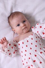 Cute newborn baby lying on bed, top view