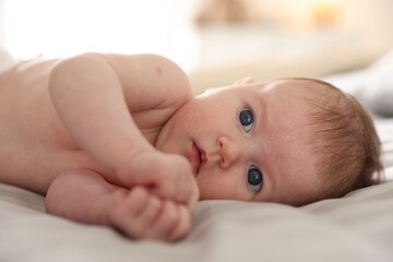 Cute newborn baby lying on bed, closeup