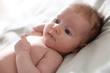 Cute newborn baby lying on bed, closeup