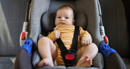 Cute little baby fastened in car seat