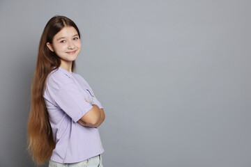 Portrait of teenage girl on grey background, space for text