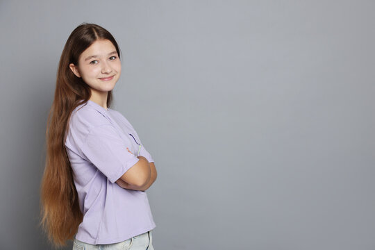 Portrait of teenage girl on grey background, space for text