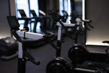 Fototapeta premium Many modern professional bicycle machines in gym, closeup