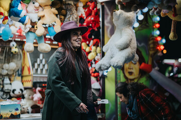 A cheerful moment captured at a carnival stall with a woman smiling and toys hanging around,...