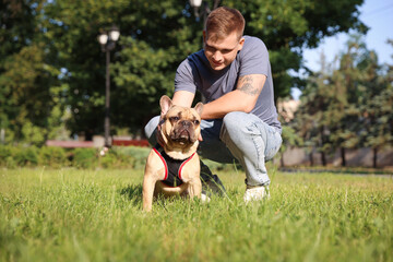 Happy man with his cute French bulldog in park