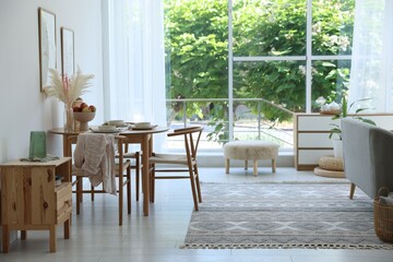 Stylish table setting, chairs and decor in dining room. Interior design