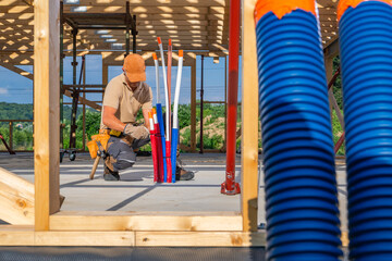 Construction Worker Organizing Pipes at a Building Site During Daytime
