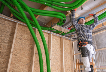Worker Installing Green Plumbing Pipes in a Construction Site During the Day
