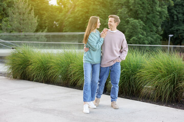 Lovely couple walking together on city street, space for text