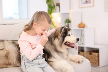 Girl suffering from allergy with her dog at home