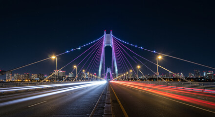 Obraz premium Modern Suspension Bridge Night Lights. Modern cable-stayed bridge illuminated with purple lights at night, long exposure with cityscape and traffic trails.