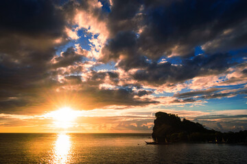 Dramatic tropical sunset over coastal rock formation. Bagulayag, Romblon, Philippines