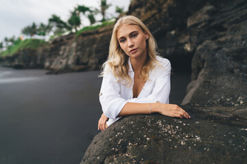Close-up portrait of thoughtful young woman leaning on rock, symbolizing inner awareness, beauty of unplugged moments, and peaceful contrast between tech-driven life and mindful existence.