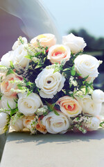 Elegant Bouquet Of White And Peach Roses With Greenery On Stone Surface, Soft Natural Light, Outdoor Setting.