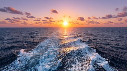 Ocean waves under a colorful sunset sky with clouds and bright sunlight.
