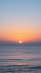 Sunset Over the Ocean: A Tranquil Horizon with Soft Orange and Blue Hues