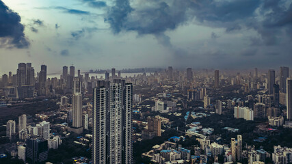 Aerial cinematic image of Mumbai during the monsoon season, featuring dramatic clouds over the city skyline. Ideal for themes like weather, travel, cityscapes, and dramatic skies.