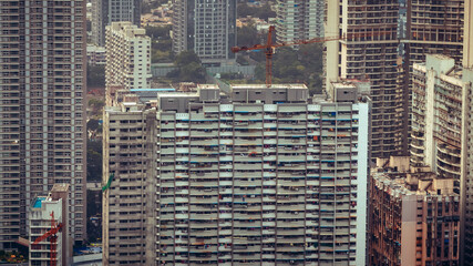 Aerial cinematic image of Mumbai during the monsoon season, featuring dramatic clouds and a glowing sunset over the city skyline. Ideal for themes like residential buildings, and urban cityscapes.