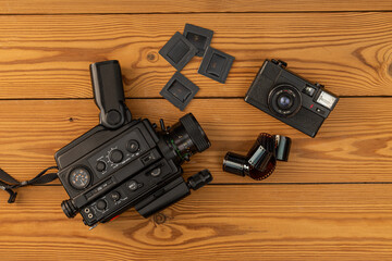 Super 8 movie camera and old 35mm movie camera with negative ,slide film on wooden background . Vintage movie camera on negative.Nostalgia concept