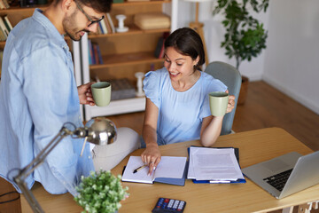 Two individuals engage in a productive collaboration in a home office, sharing ideas and enjoying...