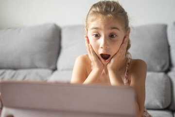 Surprised Girl Reacting to Tablet Screen at Home
