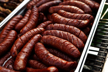 Grilled sausages in metal tray at outdoor event
