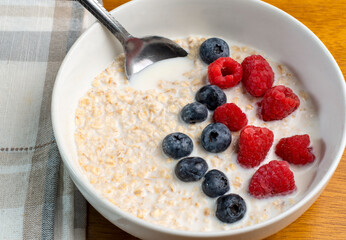 oatmeal top with red raspberries and  blueberries
