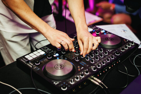 DJ hands adjusting sound mixer at event
