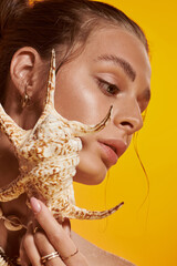 Summer vibes captured in a stylish studio with a young woman and seashell accessory