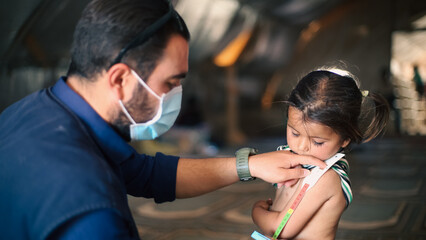 A doctor examines children's malnutrition inside a refugee camp. Malnutrition was measured using a...