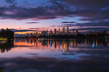 Obraz premium Melbourne, Victoria, Australia - Night view of Melbourne city lights reflecting on Albert Park Lake, with vivid colors in the sky.