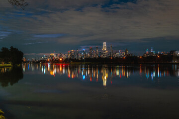Obraz premium Melbourne, Victoria, Australia - City skyline fully lit under night sky with reflections shimmering in Albert Park Lake.