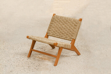 a stylish lounge chair made of teak wood with woven rattan-style seating and backrest. The design...
