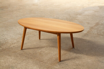 a minimalist teak wood coffee table with a smooth oval top and four tapered legs. The clean design and natural wood finish make it perfect for modern, Scandinavian, or Japandi-style interiors.