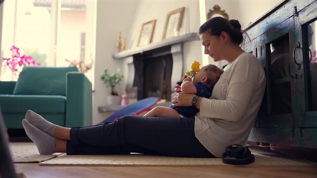 Mother sitting on floor with baby, supporting early play, encouraging exploration, hands-on parenting, warm and loving home environment, secure childhood moments